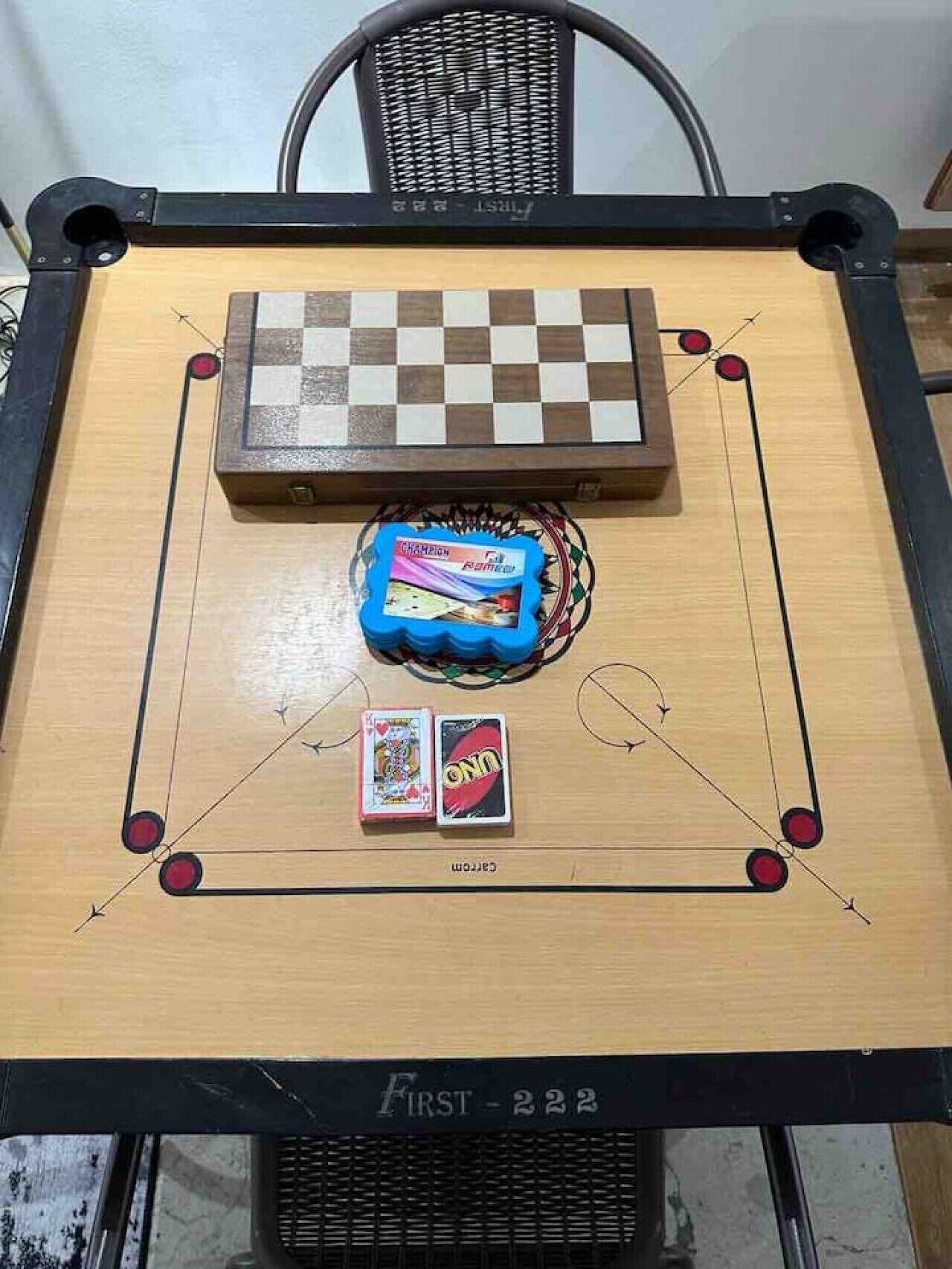 A checkered board game with cards and a blue object on a table.