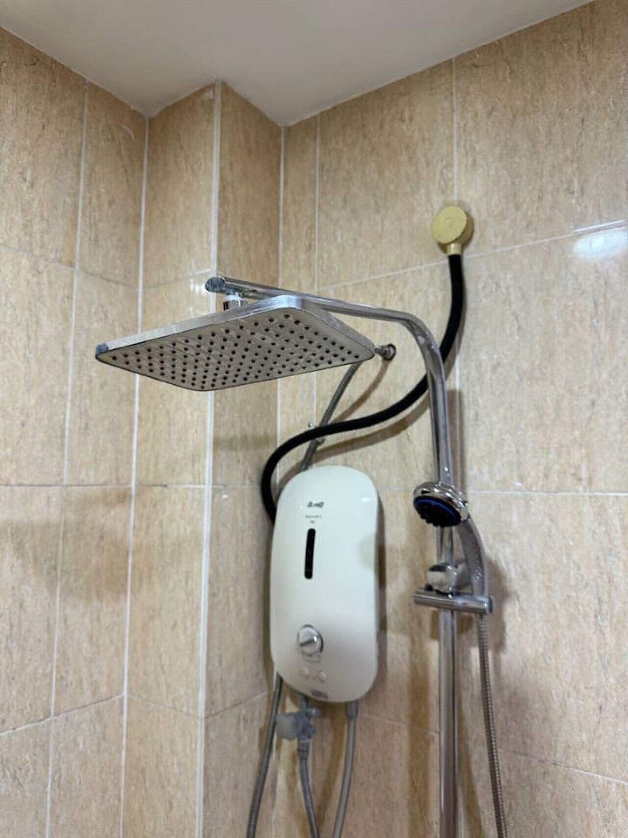 A shower with a handheld showerhead and a wall-mounted control panel.