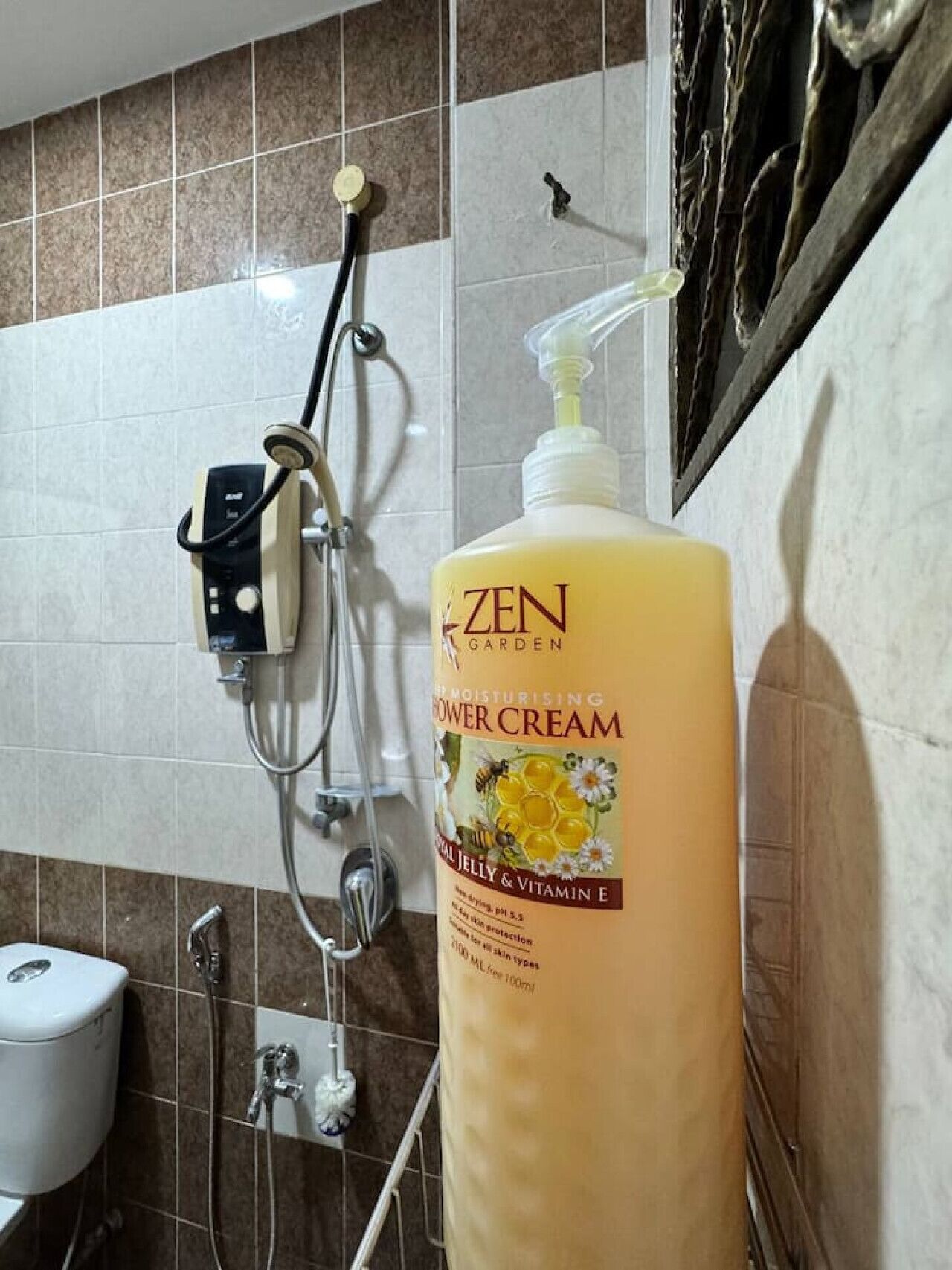 Une salle de bain équipée d’une douche, de toilettes et d’un grand flacon de crème de douche hydratante Zen Garden.