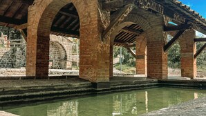 Un pont de pierre avec des arches et un bassin en premier plan.