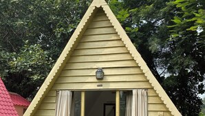 A triangular-shaped building with a balcony, a small window, and a door with curtains. - Panchet Residency (Raghunathpur)