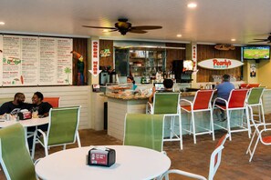 A restaurant with a counter, menu boards, and seating areas.