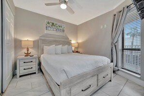Drift off under the gentle breeze of your ceiling fan, wrapped in crisp linens and soft coastal light. Your peaceful retreat awaits, styled with coastal charm and everything you need for a restful night.