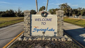 A welcome sign for SpringLake with a stone border and a wreath on top.