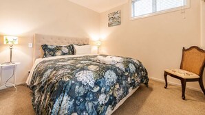 A bedroom with a bed, two bedside lamps, a chair, and a window. - Starlight Suite | Tekapo 1BR + Lake Walk (Lake Tekapo)