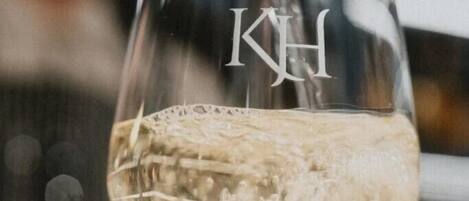 Un vaso con la letra 'KH' que se llena con un líquido transparente, probablemente una bebida.