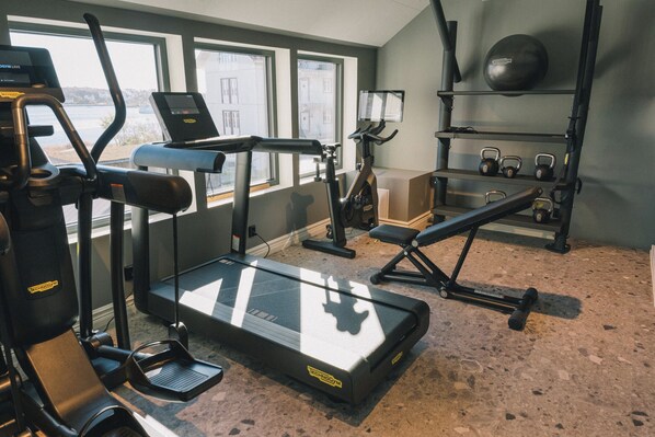A gym with cardio machines, weights, and a treadmill. - Kusthotellet Styrsö (Styrso)