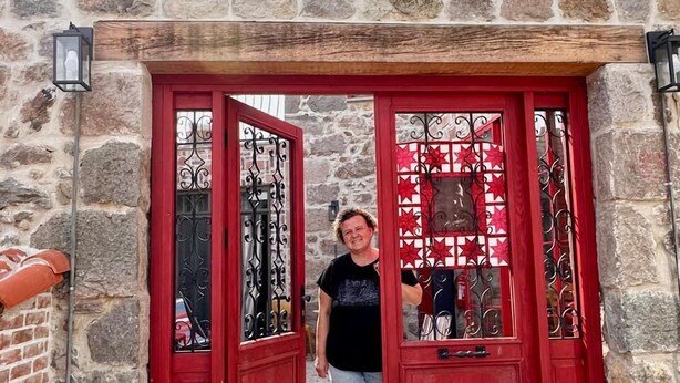Un edificio de piedra con una puerta roja y un gato en los escalones.