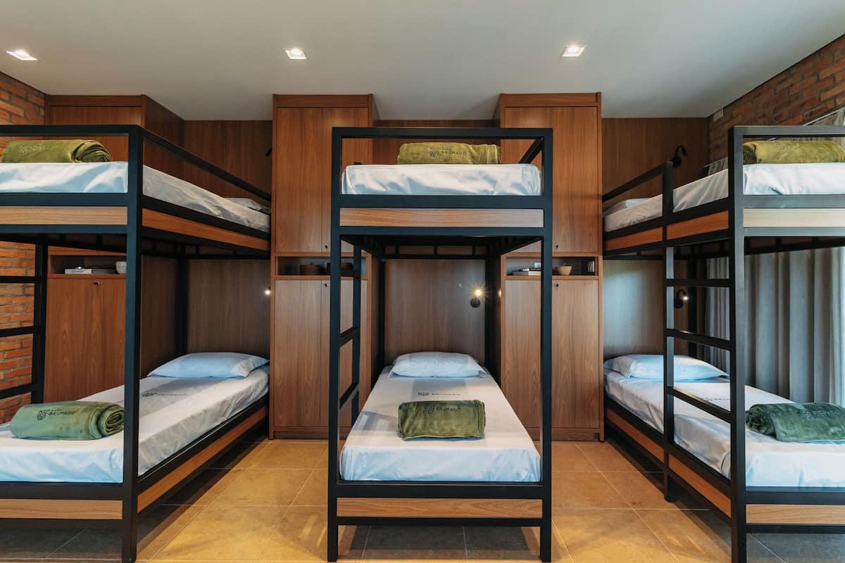 Dormitorio con literas, paredes de madera y suelo de baldosas.