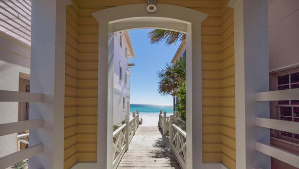 Un sentier en bois mène à une plage d’où l’on a une vue dégagée sur l’océan.
