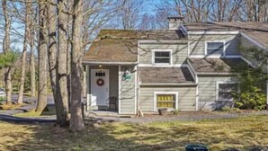 A two-story house with a front porch, a garage, and a small front yard.