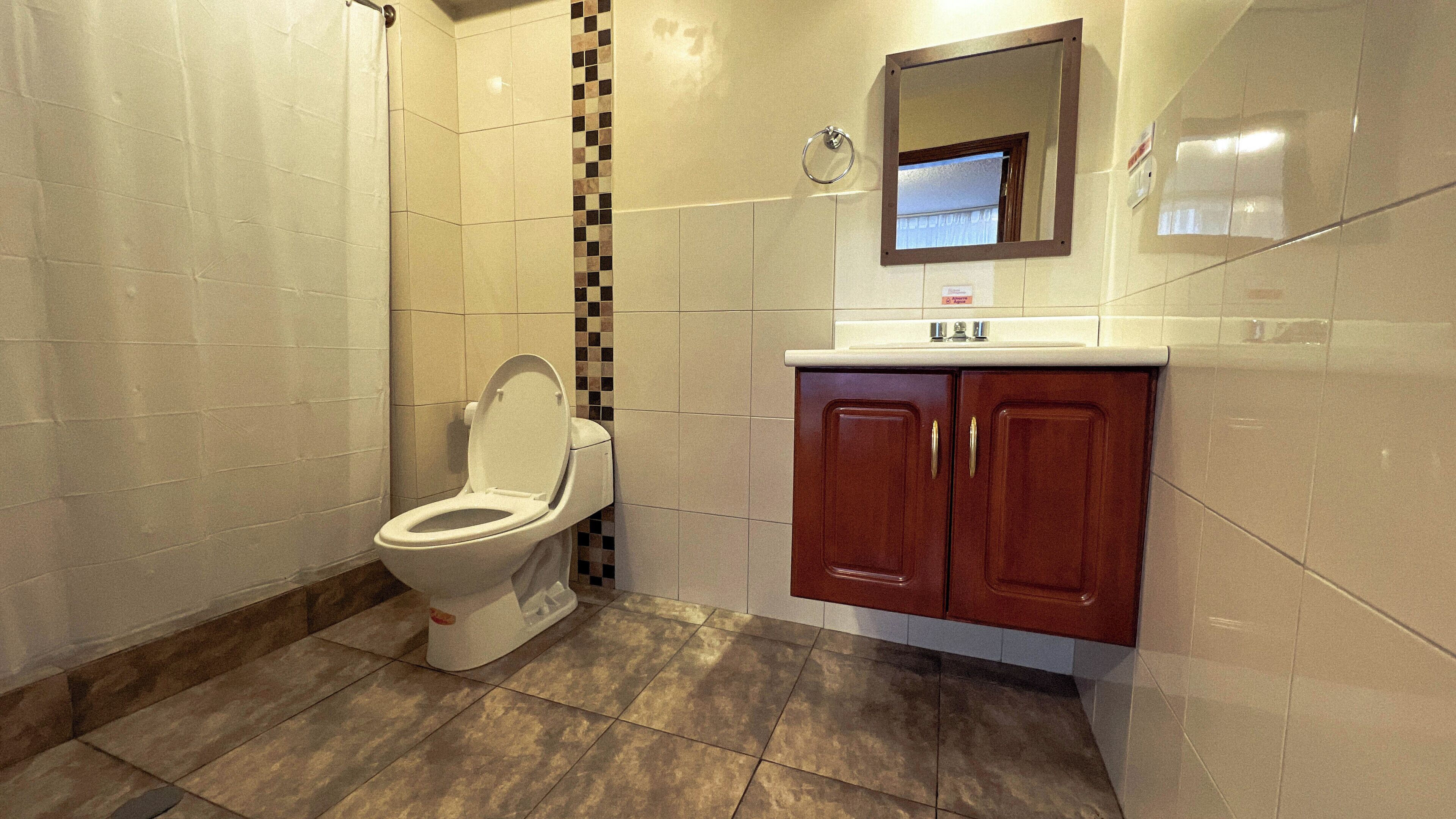 Un bagno con il water, un lavandino e uno specchio.