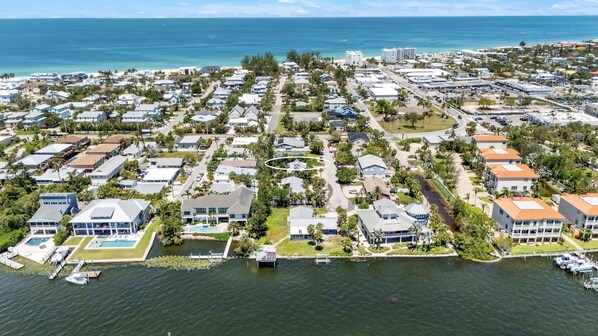 A coastal residential area with houses, a marina, and a view of the ocean.