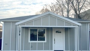 Une maison de plain-pied avec un porche à l’avant, un garage et une grande fenêtre.