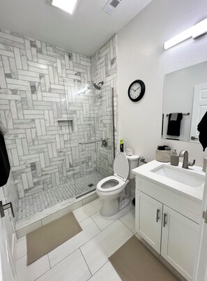 Chuveiro, toalhas de banho, sabonete, papel higiênico
