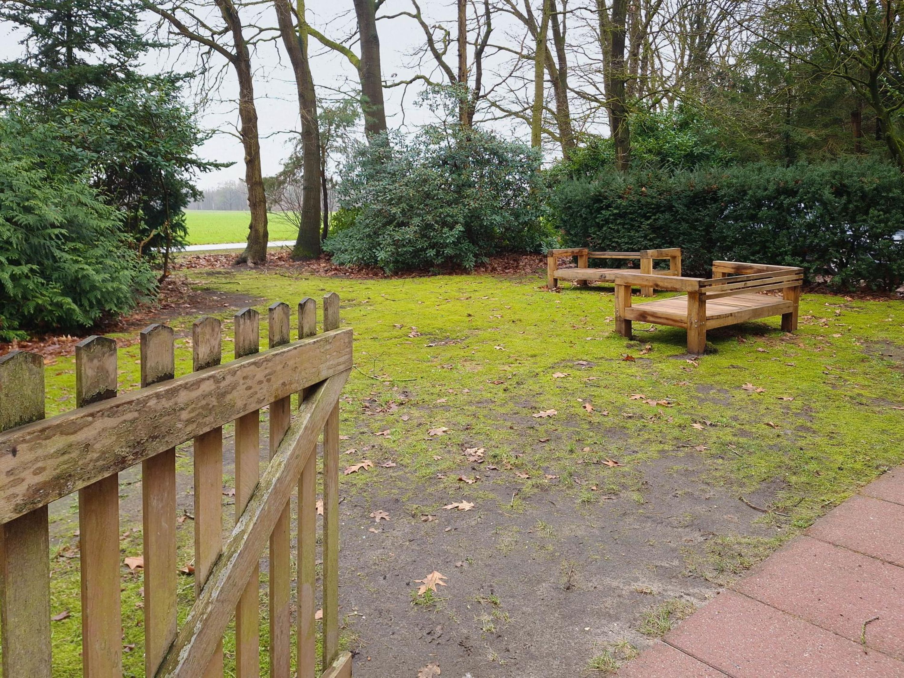 Un parc avec un banc en bois et une clôture en bois.