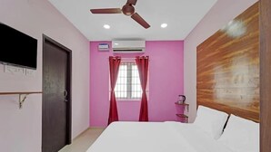 Un dormitorio con cama, ventilador de techo, equipo de aire acondicionado, ventana con cortinas y cabecera de madera.