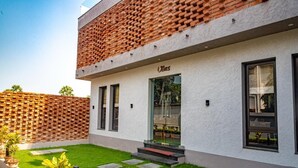 A modern building with a white facade and a brick roof. - UDICHI REGENCY (Bolpur)