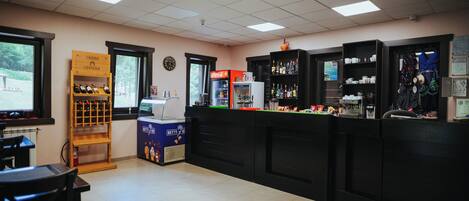 A restaurant interior with a bar area, seating, and a Coca-Cola refrigerator.