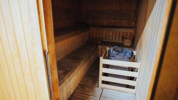 Una sauna con bancos de madera y una pequeña mesa de madera.
