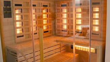 Una sauna con paredes de vidrio, interior de madera y varios bancos.