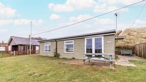 A single-story mobile home with a small patio area and a picnic table.