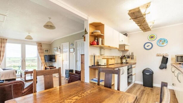A spacious kitchen with wooden cabinets, a dining table, and a view of the outdoors.