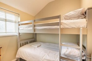 A bunk bed room with a window, a radiator, and a bedside table. - Host & Stay | Cromer Town, Apartment 1 (Cromer)