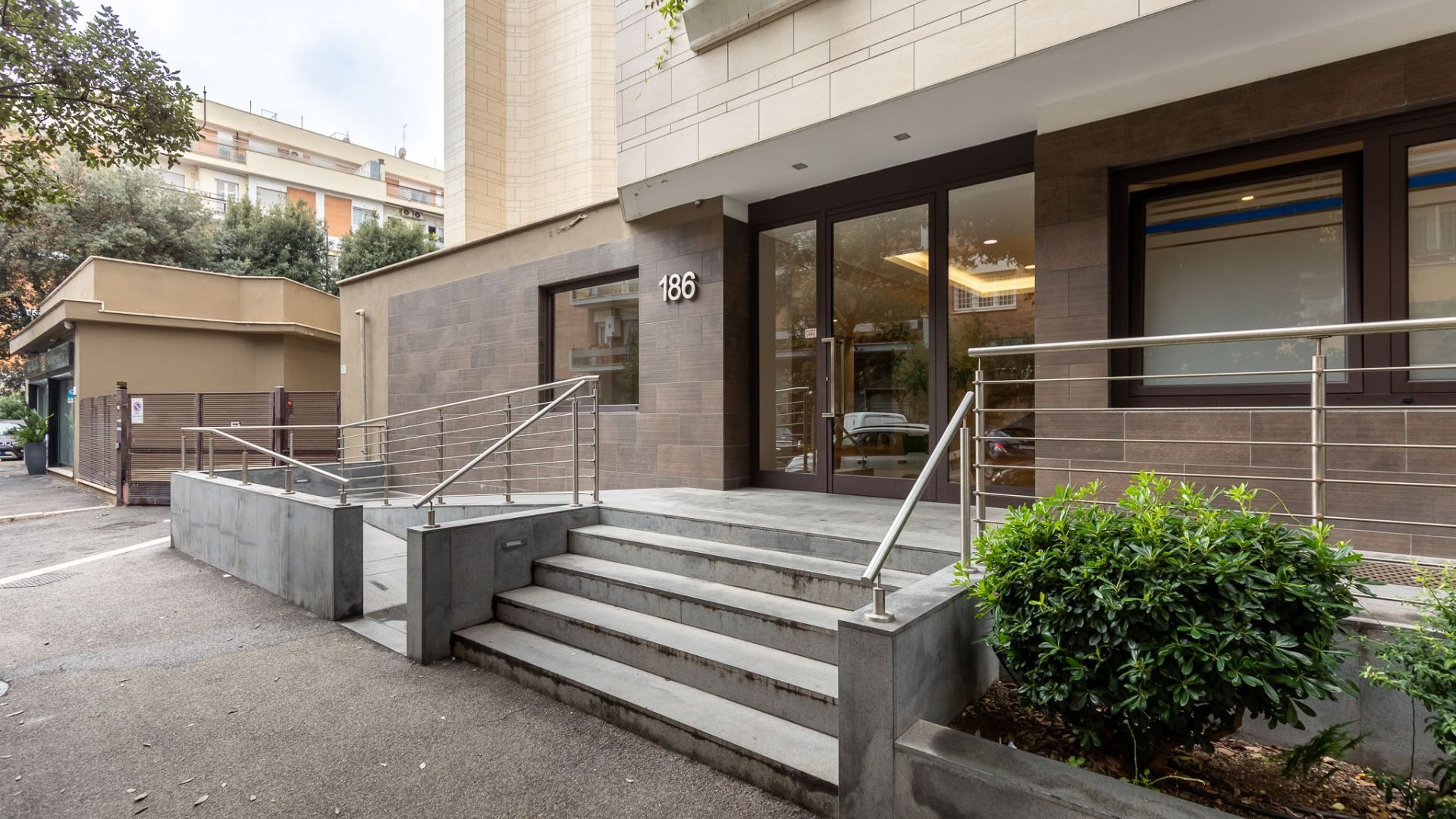 A building entrance with a staircase leading to a door marked with the number 186.