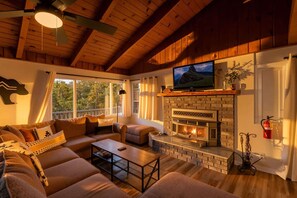 A cozy living room with a fireplace, a television, and a sofa.