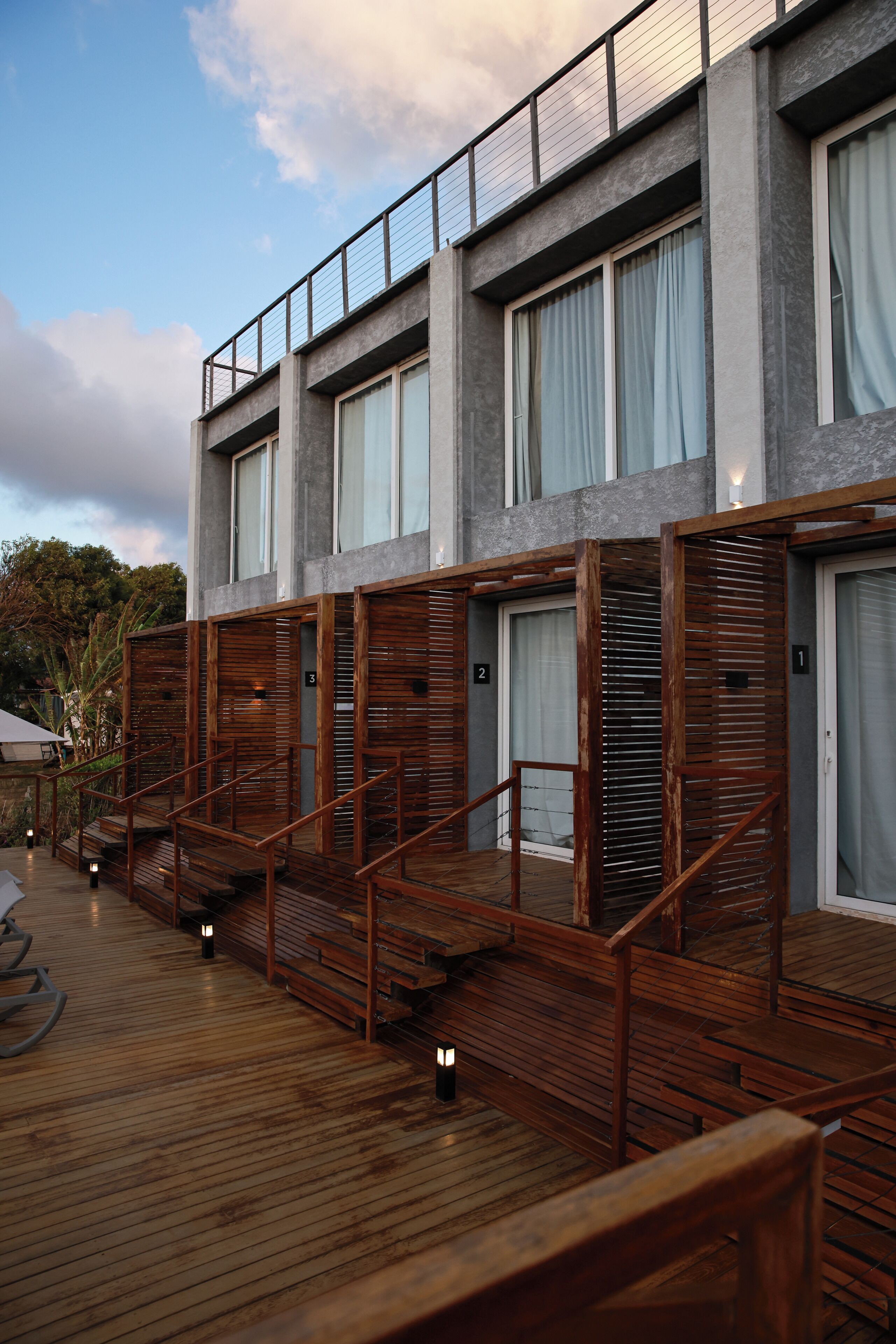 A modern building with multiple rooms, wooden staircases, and a wooden deck.