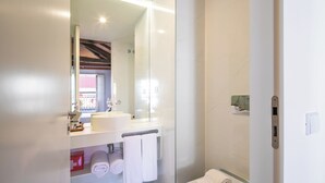 Un bagno moderno con cabina doccia in vetro, lavandino bianco e water.