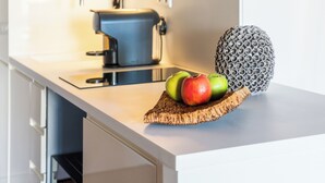 Un piano di lavoro da cucina con un tostapane, un'ananas e delle mele.