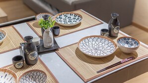 A dining table with various Japanese dishes and utensils. - [NEW] Private Jacuzzi | Near Velocity Mall | MRT | Retro Games (Cheras)