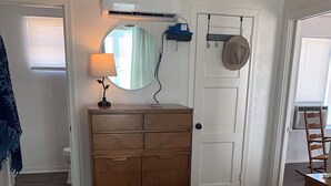Ein Schlafzimmer mit Bett, Schminktisch, Spiegel und Tür.
