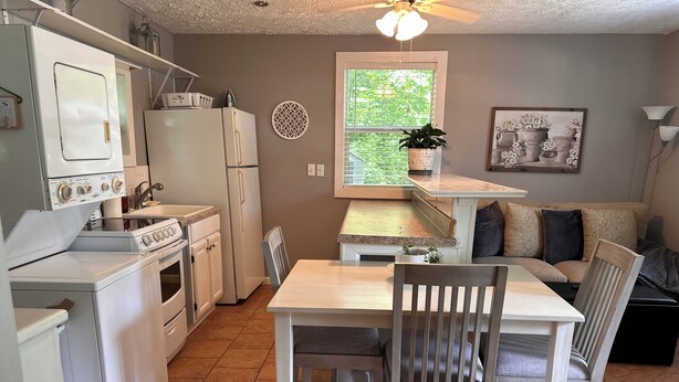A compact kitchen with a dining area, a refrigerator, a stove, and a sink. - Little Southern Charm in tranquil Flovilla with AC, WiFi (Flovilla)