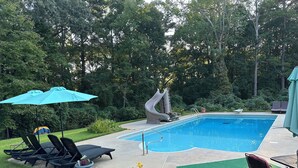 A backyard with a swimming pool, lounge chairs, and a slide. - Little Southern Charm in tranquil Flovilla with AC, WiFi (Flovilla)