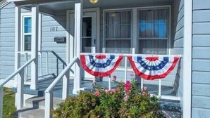 A house with a porch, a number '101' on the door, and a flag decoration. - Tinker AFB OKC I-40 Colonial Dorchester Cottage (Midwest City)