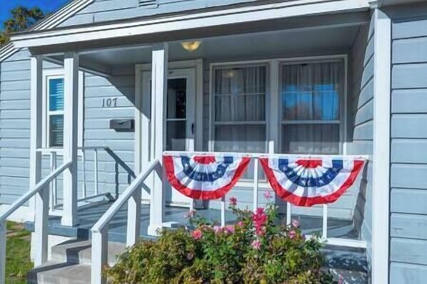 A house with a porch, a number '101' on the door, and a flag decoration.