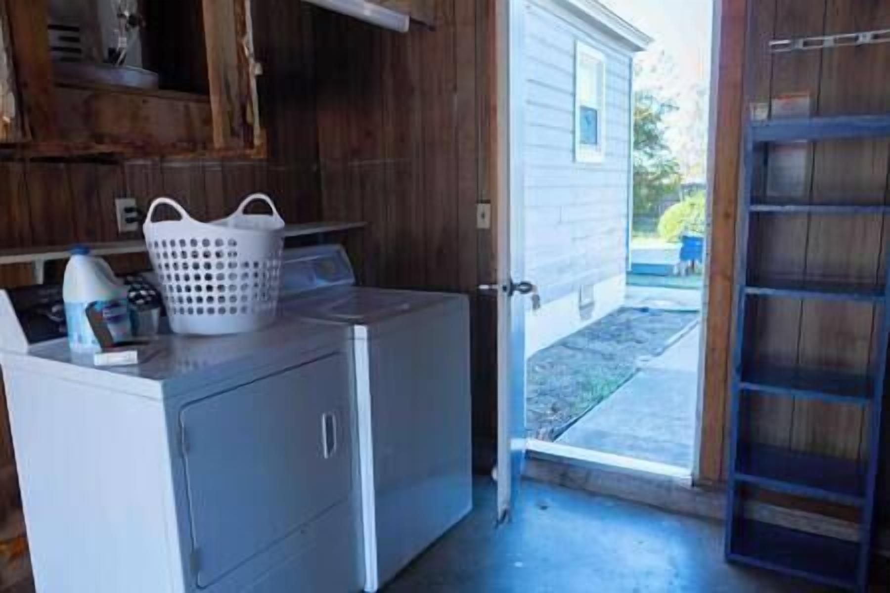 A laundry area with a washing machine, a dryer, and a white laundry basket on a counter.