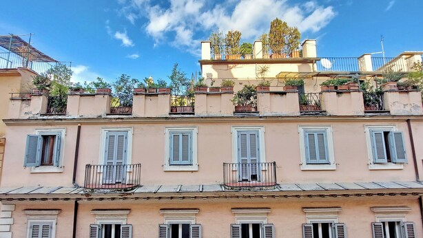 A multi-story building with balconies and windows, featuring a traditional architectural style.