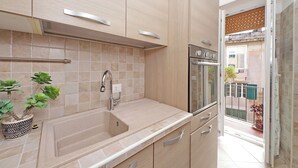 A modern kitchen with a sink, stove, and cabinets.