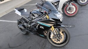 A black motorcycle with gold accents parked in a lot. - Mountain Views , Skiing, Lake & Coffee Bar (Ogden)