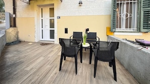 An outdoor patio with two black wicker chairs and a small table, a door, and a window with green shutters. - Appartamento Soul & Travel Ac And Wifi (Opatija)