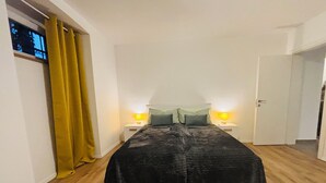A bedroom with a bed, two bedside tables with lamps, a window with curtains, and a door. - Appartamento Soul & Travel Ac And Wifi (Opatija)