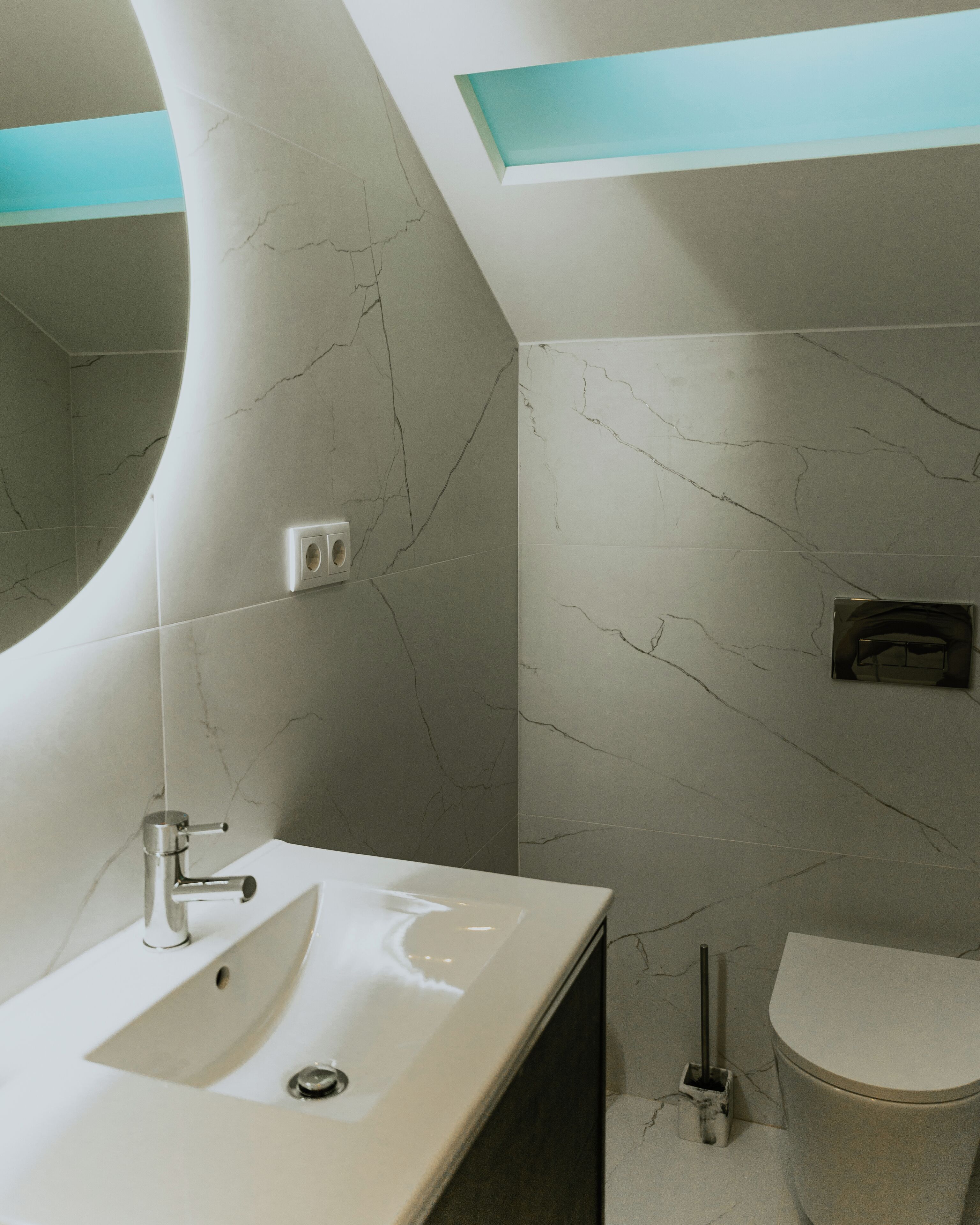Een moderne badkamer met een gebogen wastafel, een toilet en een douchehoek.