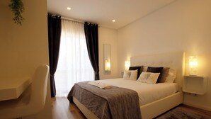 Un dormitorio moderno con una cama grande, un escritorio y una silla.