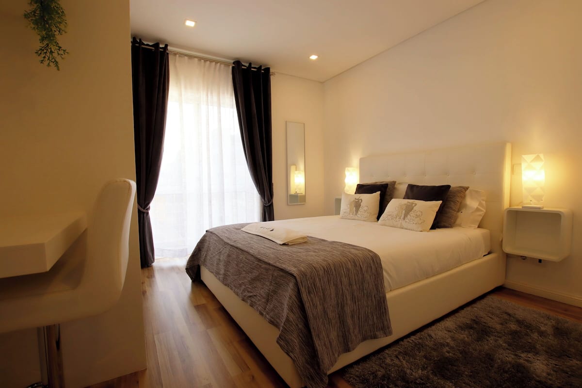 Ein modernes Schlafzimmer mit einem großen Bett, einem Schreibtisch und einem Stuhl.