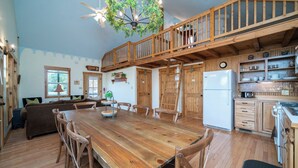 A spacious kitchen with wooden cabinets, a dining table, and a built-in stove.