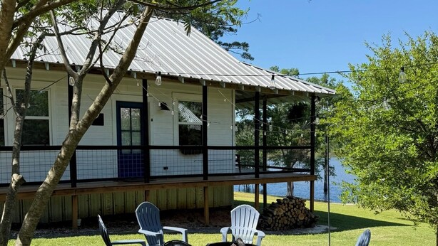 A house with a porch, outdoor seating, and a fire pit.